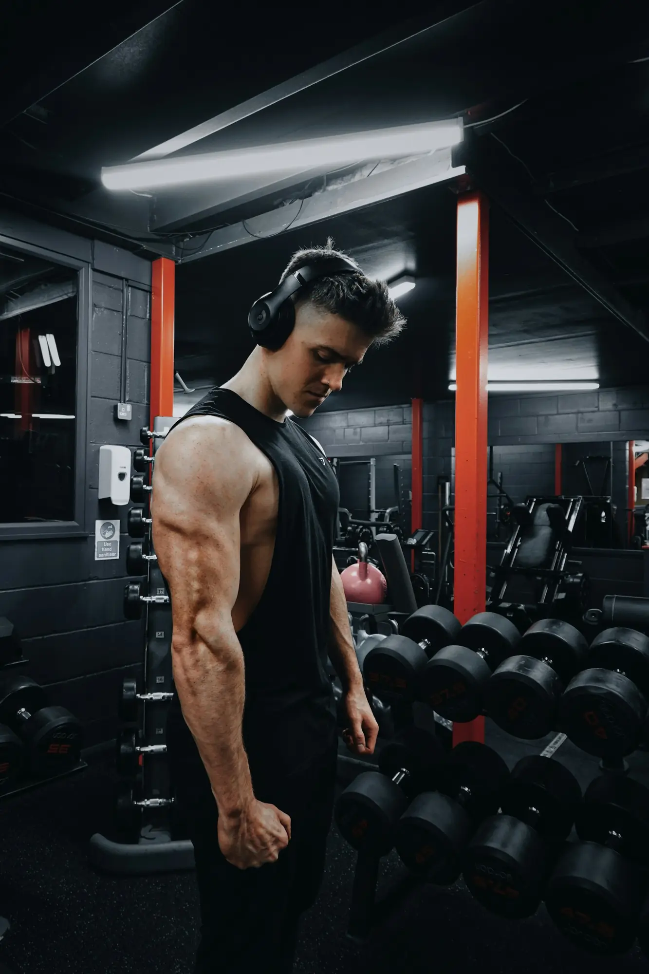A lifter between sets at the dumbbell rack