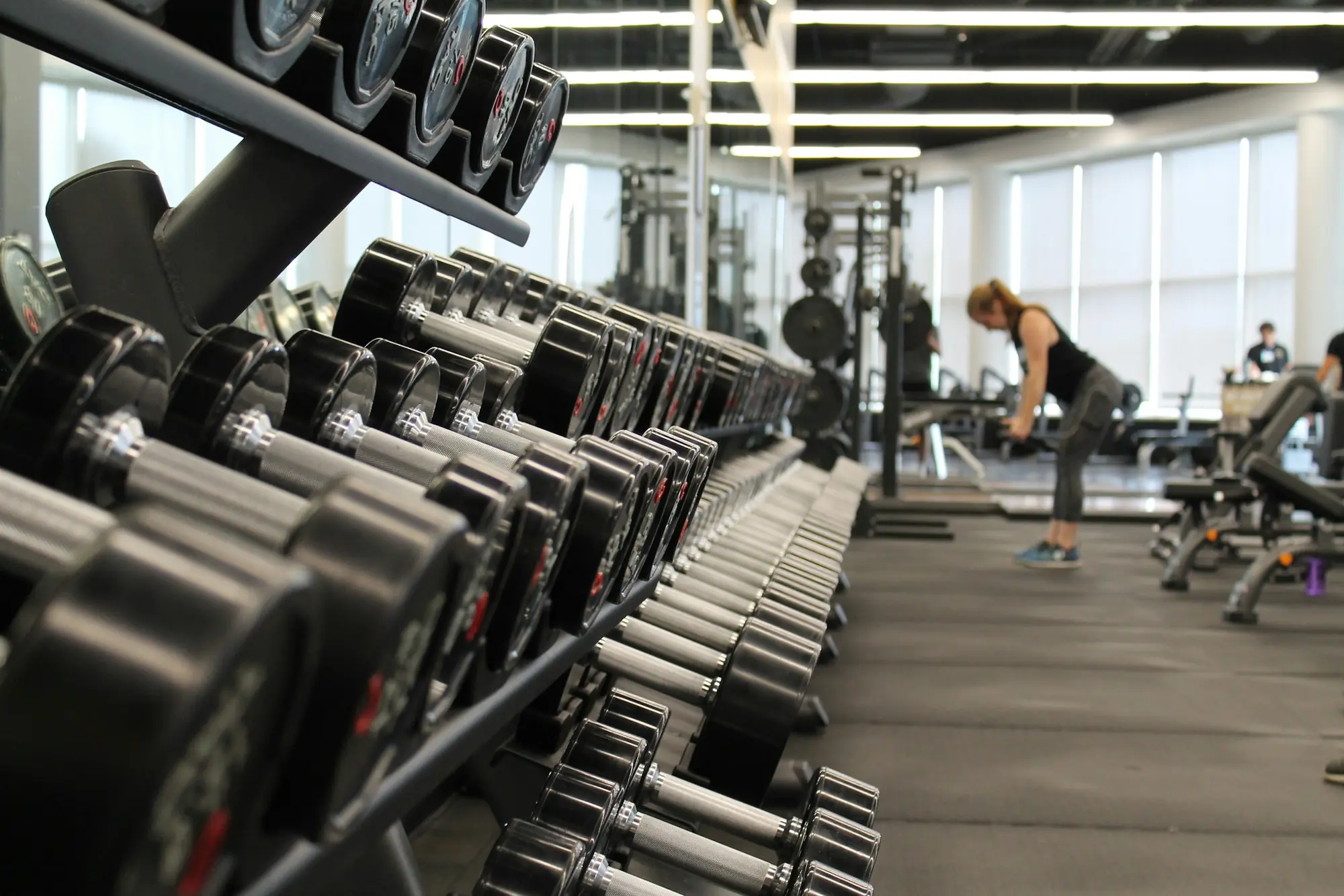 A long dumbbell rack running down the gym floor